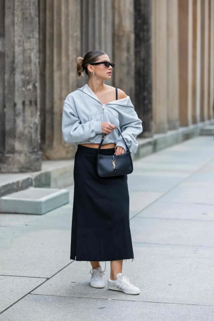 Sunglasses, a leather vest, a midi skirt, some socks, and loafers.